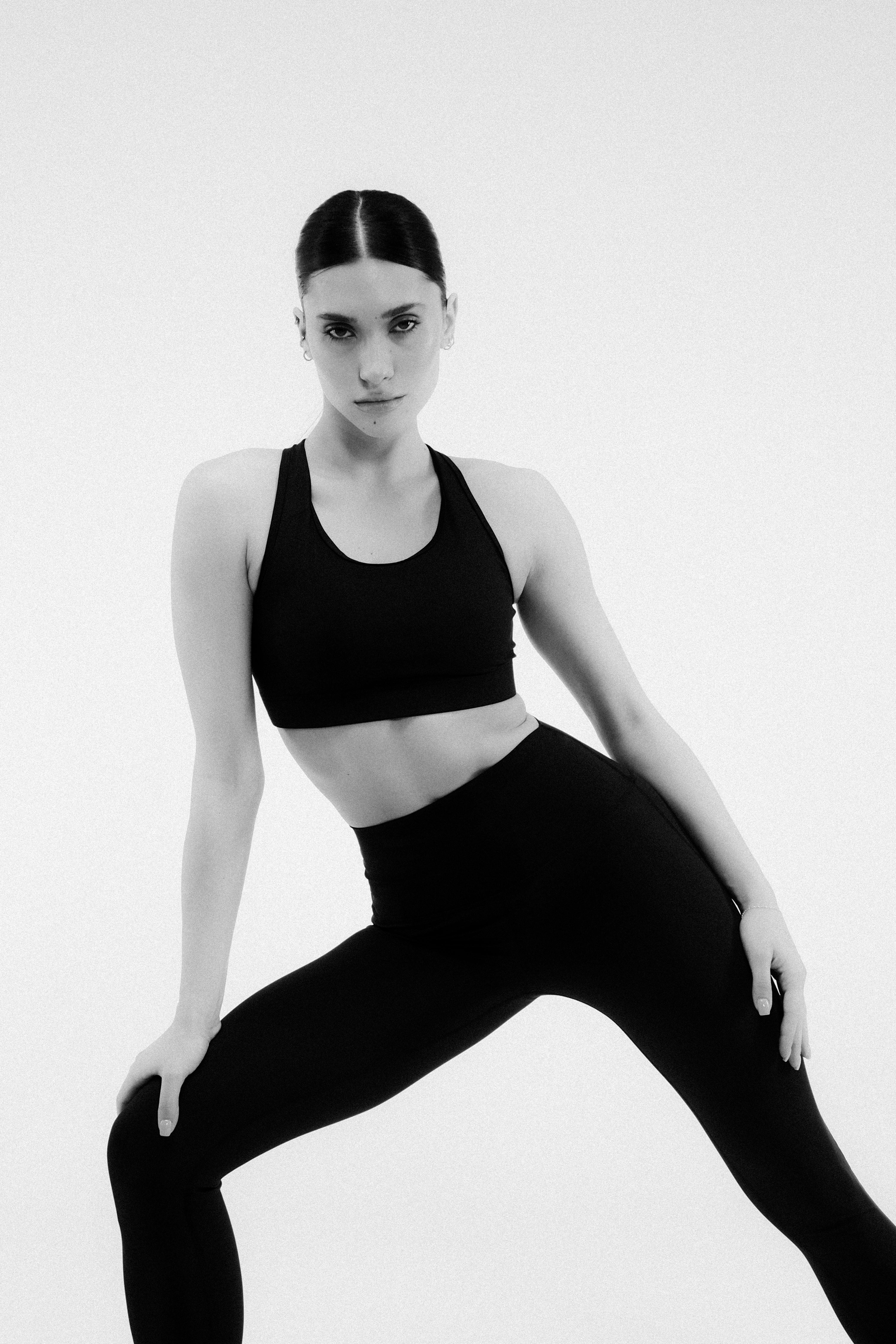 LIGAS — model in black sports bra and high-waisted leggings, B&W studio shot, mobile homepage hero